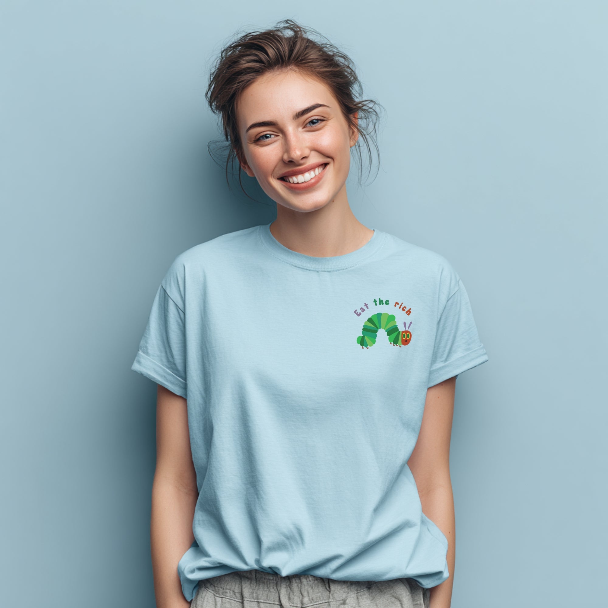 Modell trägt hellblaues T-Shirt mit Raupe Nimmersatt und „Eat the Rich“ Brustaufdruck, politisches Statement-Shirt