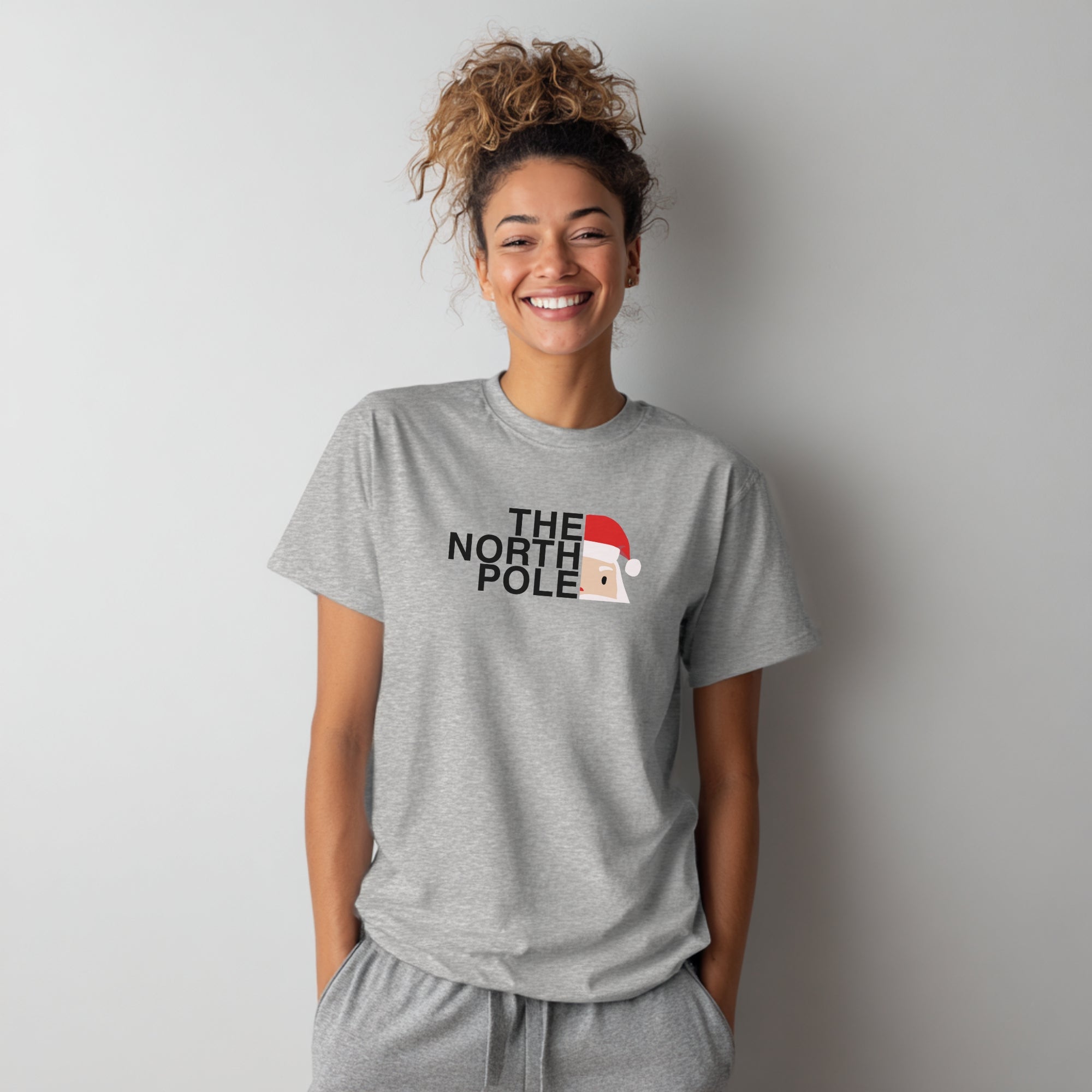 Modell trägt hellgraues T-Shirt mit „The North Pole“-Aufdruck, lustiges Weihnachtsmotiv
