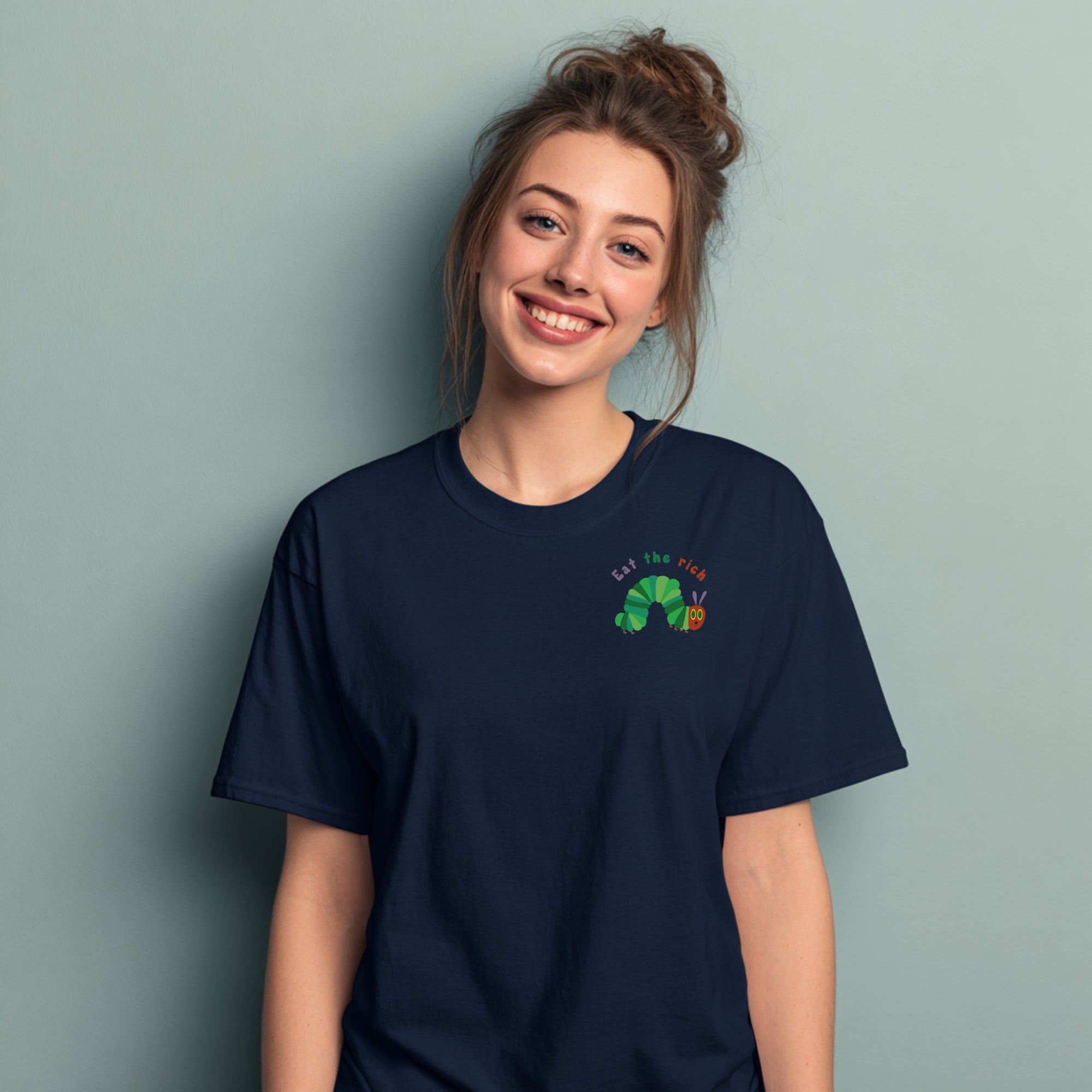 Modell trägt marineblaues T-Shirt mit Raupe Nimmersatt und „Eat the Rich“ Brustaufdruck, politisches Statement-Shirt