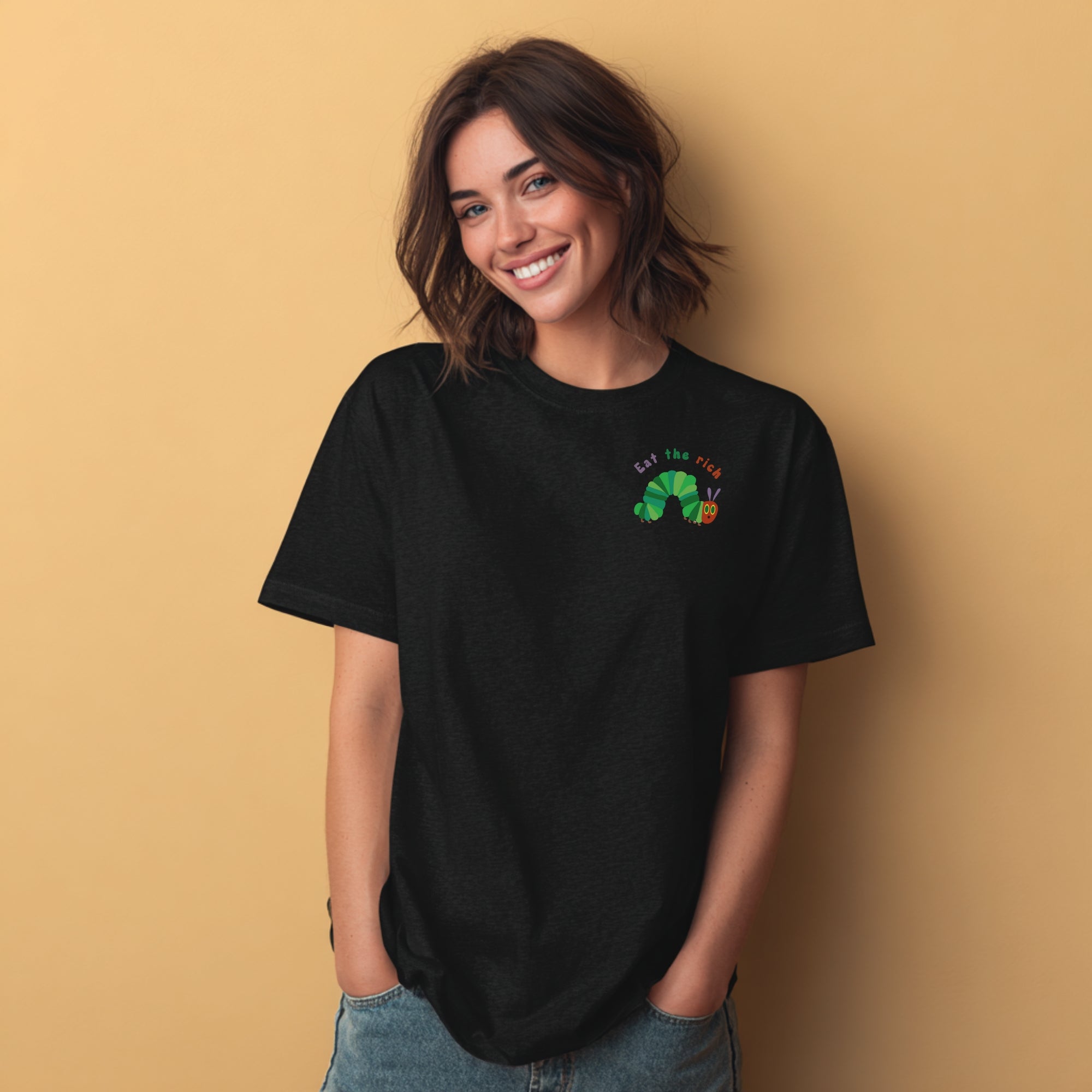 Modell trägt schwarzes T-Shirt mit Raupe Nimmersatt und „Eat the Rich“ Brustaufdruck, politisches Statement-Shirt